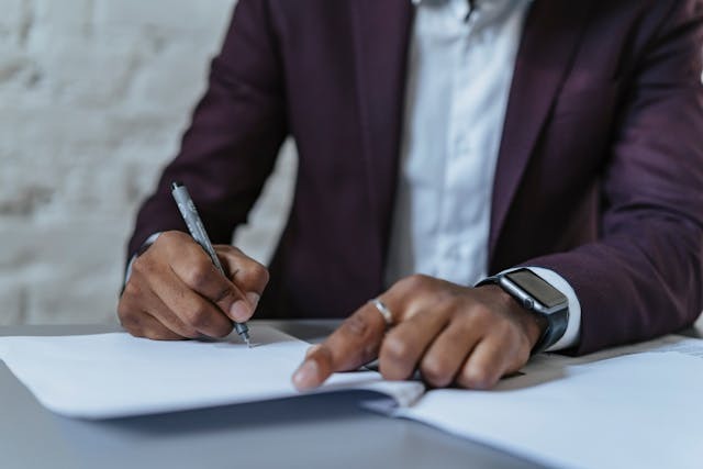 person noting something down on a bunch of papers